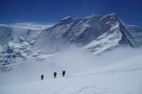 Cordée d'alpinistes progressant sur les pentes enneigées du Putha Hiunchuli, sommet himalayen à plus de 7 000 mètres