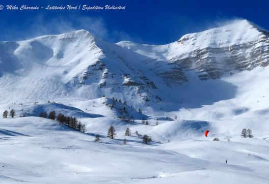 Snowkiteur avec une voile rouge dans les Alpes