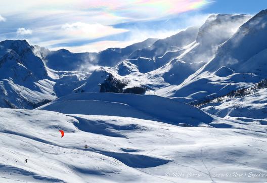Snowkiteur dans le Alpes avec une voile Rouge
