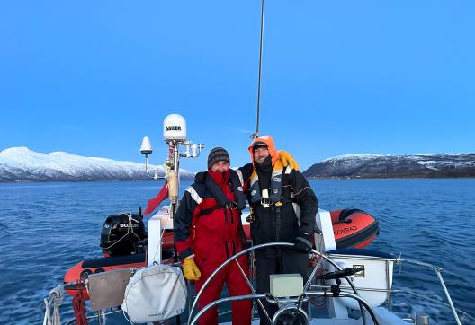 Navigation du guide et du skipper en voilier dans les fjords de Troms sous les sommets enneigés de l'Arctique norvégien