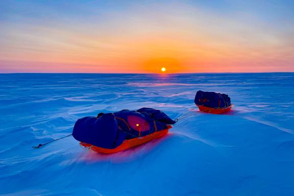Expédition Pulkas alignés dans la neige sous le coucher de soleil