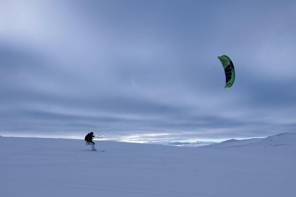 Sortie snowkite avec voile verte au crépuscule en Scandinavie