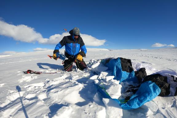 Un guide snowkite ancre sa voile lors d'une descente dans le Norvège du Sud