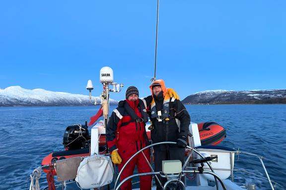 Navigation du guide et du skipper en voilier dans les fjords de Troms sous les sommets enneigés de l'Arctique norvégien