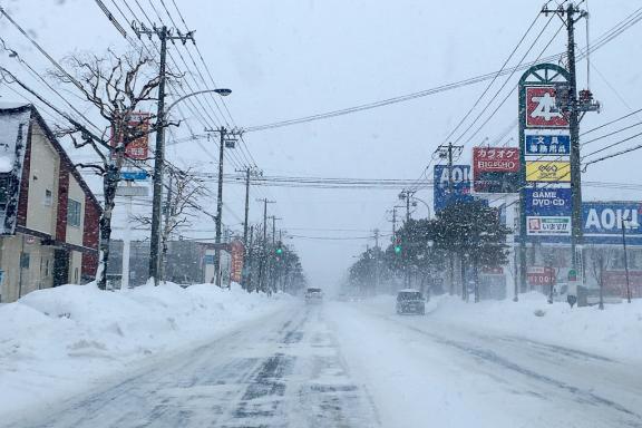 Voyage ski à Hokkaido sur une route urbaine enneigée, dans l’ambiance hivernale des villes du nord du Japon