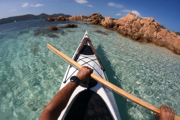 Kayak de mer dans un lagon turquoise bordé de rochers granitiques en Sardaigne