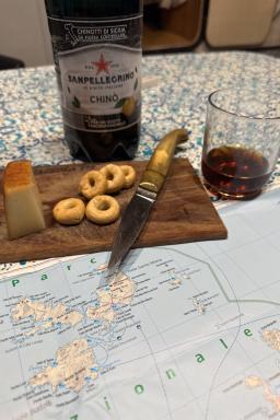 Découverte gastronomique autour d’un apéritif sarde sur une carte marine après une expédition en kayak de mer en Sardaigne